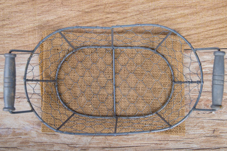 Empty iron basket on a wooden background. Top viewの写真素材