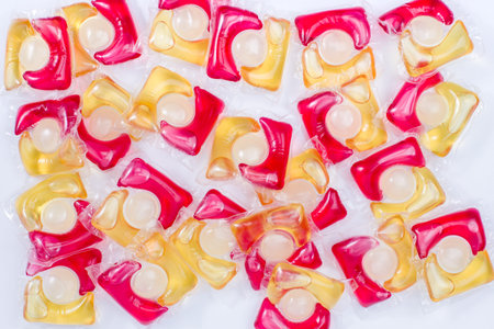 Capsules with washing gel in red, yellow and white colors. Top view.