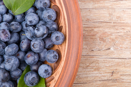 Blueberries in a bowl on wooden table. Top view with copy spaceの写真素材
