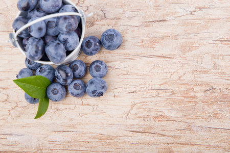 Fresh blueberries with leaves on wooden background. Top view with copy spaceの写真素材