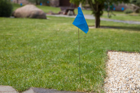 Blue flag on a stick in the garden. Marking the area with sprinklers on the lawn.の写真素材