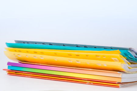 Stack of colorful folders on white background. Copy space for text.の写真素材