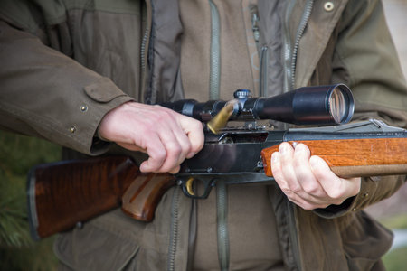 Close-up of a man's hands holding a hunting rifle.