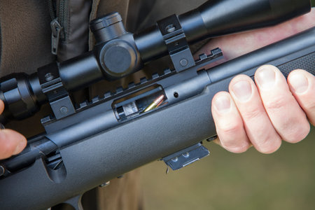 Close-up of a man's hand holding a sniper rifle.