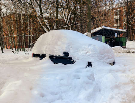 Car under a thick layer of snow, Russian winter in a small town.の写真素材
