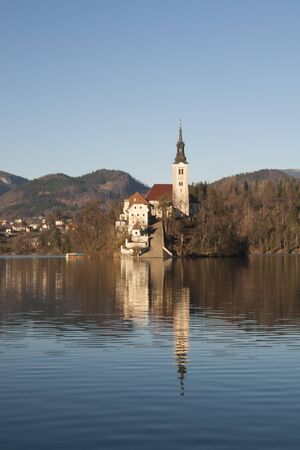 Bled island with church on it. Famous landmark in the middle of the Lake Bled in Slovenia. Winter scene of popular tourist destination.の写真素材