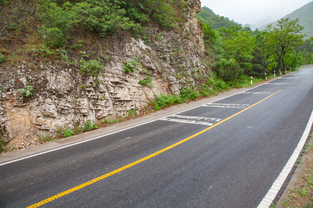 The rugged mountain road is shrouded in haze in Beijing, Chinaの写真素材