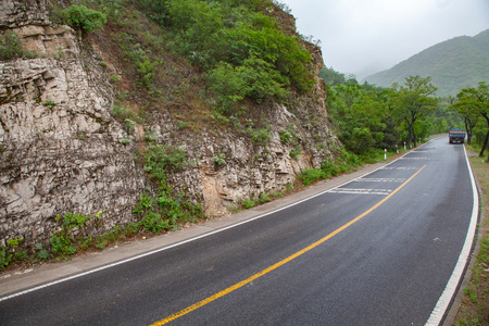 The rugged mountain road is shrouded in haze in Beijing, Chinaのeditorial素材