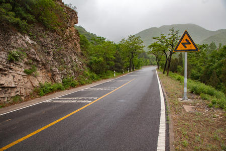 The rugged mountain road is shrouded in haze in Beijing, Chinaの写真素材