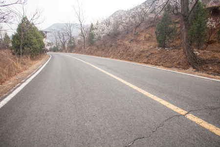 The rugged mountain road is shrouded in haze in Beijing, Chinaの写真素材