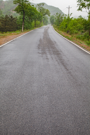 The rugged mountain road is shrouded in haze in Beijing, Chinaの写真素材