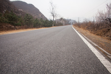 The rugged mountain road is shrouded in haze in Beijing, Chinaの写真素材