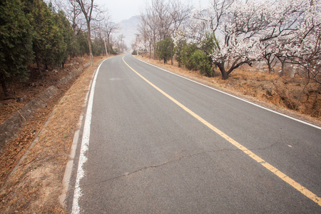 The rugged mountain road is shrouded in haze in Beijing, Chinaの写真素材