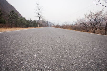 The rugged mountain road is shrouded in haze in Beijing, Chinaの写真素材