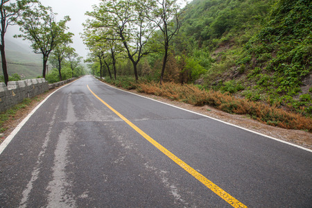 The rugged mountain road is shrouded in haze in Beijing, Chinaの写真素材