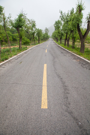 The rugged mountain road is shrouded in haze in Beijing, Chinaの写真素材