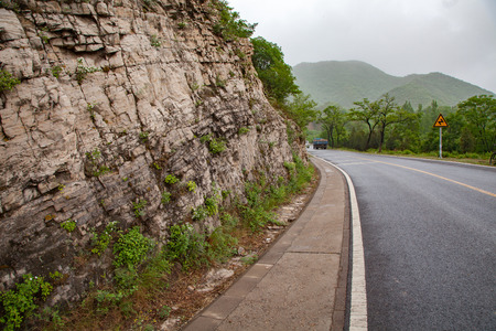 The rugged mountain road is shrouded in haze in Beijing, Chinaのeditorial素材