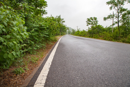 The rugged mountain road is shrouded in haze in Beijing, Chinaの写真素材