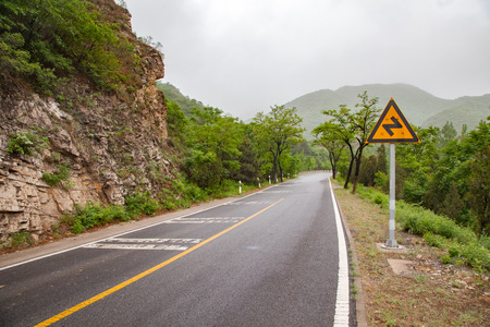 The rugged mountain road is shrouded in haze in Beijing, Chinaの写真素材