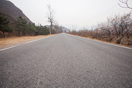 The rugged mountain road is shrouded in haze in Beijing, Chinaの写真素材