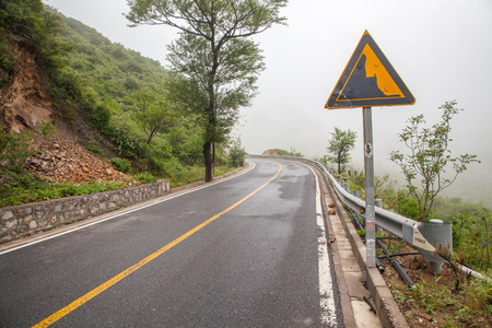The rugged mountain road is shrouded in haze in Beijing, Chinaのeditorial素材