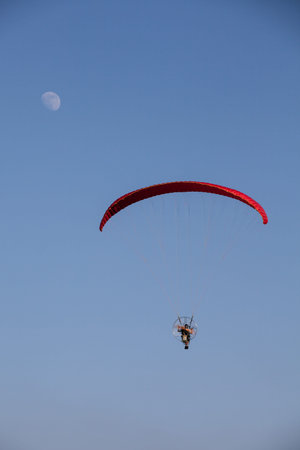 paramotor flying on blue sky