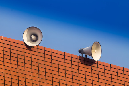 white loudspeakers on builing and bule sky background.の写真素材