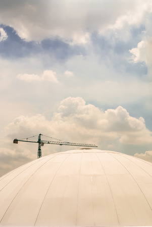 crane work behind the dome on sky background.の写真素材
