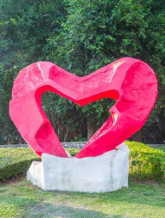 Red heart statue in garden.の写真素材