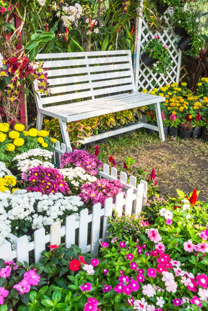 White wooden chair in the flowers garden.の写真素材