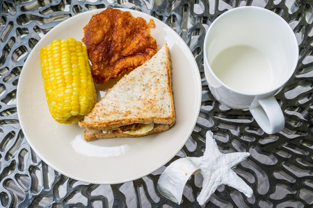 Sandwich, Fried chicken and Corn boil, Breakfast set on relaxing terrace.の写真素材