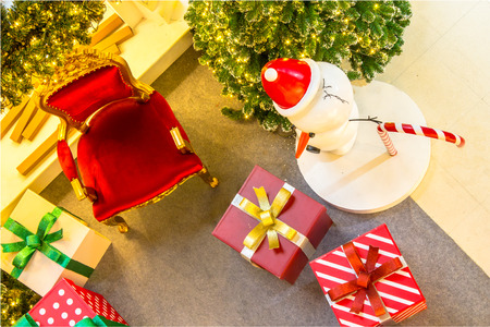 Ready for CHristmas,  Adorned Christmas Tree , Chair ,  Fireplace, Snowman, Gift  inside Living space with copyspace.の写真素材