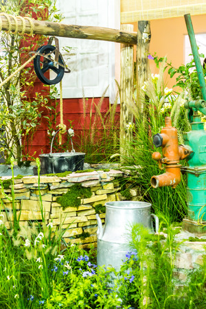 Artesian well and bucket in cozy garden on summer.の写真素材