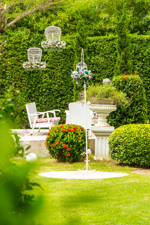 White table set and flower pot on relaxing space in cozy garden on summer.の写真素材