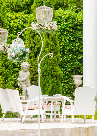 White table set and flower pot on relaxing space in cozy garden on summer.の写真素材