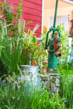 Artesian well and bucket in cozy garden.の写真素材