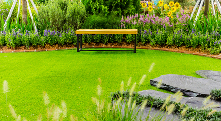 Wood couch in flower cozy garden.の写真素材