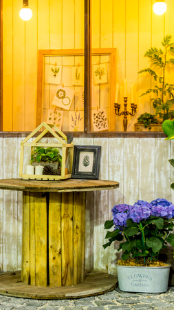 Relaxing area with table set and flower pot near window in cozy home.の写真素材