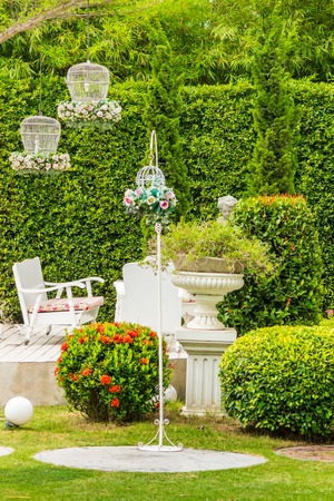 White tableset and flower pot on relaxing space in cozy garden on summer.の写真素材