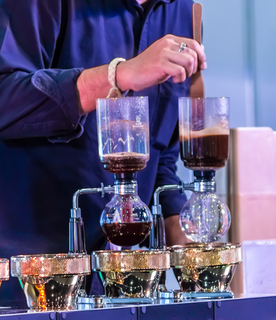Syphon Coffee or Vacuum Coffee is full immersion tasteful, Blended smell and taste of roasted coffee with direct contact boiled water and show Mix coffee beans into boiling water and stir 10 time.の写真素材