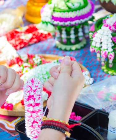Thai woman making a tradition Thai flowers garland activities in Songkran festival, Bangkok Thailand.の写真素材