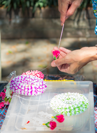 Thai woman making a tradition Thai flowers garland activities in Songkran festival, Bangkok Thailand.の写真素材