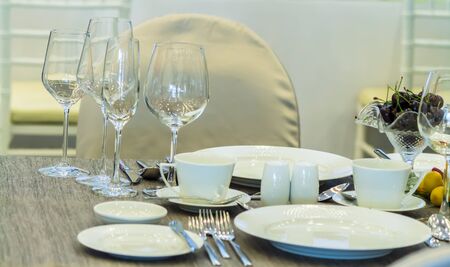 Party dinner table setting with tableware and silverware and glasses set and Candlestick and flower in restaurant.の写真素材