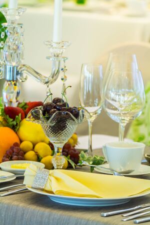Party dinner table setting with tableware and silverware and glasses set and Candlestick and flower in restaurant.の写真素材