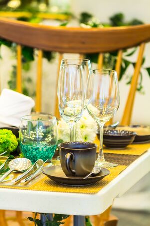 Party dinner table setting with tableware and silverware and glasses set and Candlestick and flower in restaurant.の写真素材