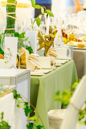 Party dinner table setting with tableware and silverware and glasses set and Candlestick and flower in restaurant.の写真素材