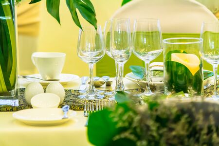 Party dinner table setting with tableware and silverware and glasses set and Candlestick and flower in restaurant.の写真素材