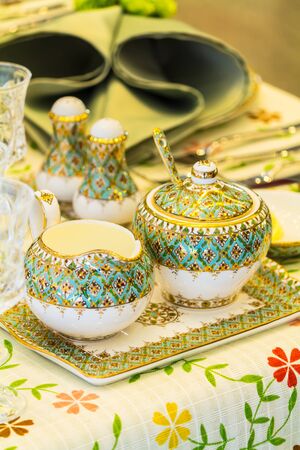 Party dinner table setting with tableware and silverware and glasses set and Candlestick and flower in restaurant.の写真素材
