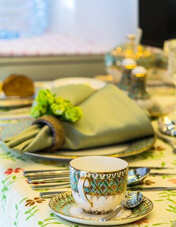 Party dinner table setting with tableware and silverware and glasses set and Candlestick and flower in restaurant.の写真素材
