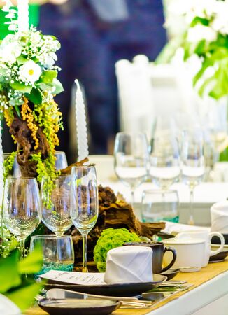 Party dinner table setting with tableware and silverware and glasses set and Candlestick and flower in restaurant.の写真素材